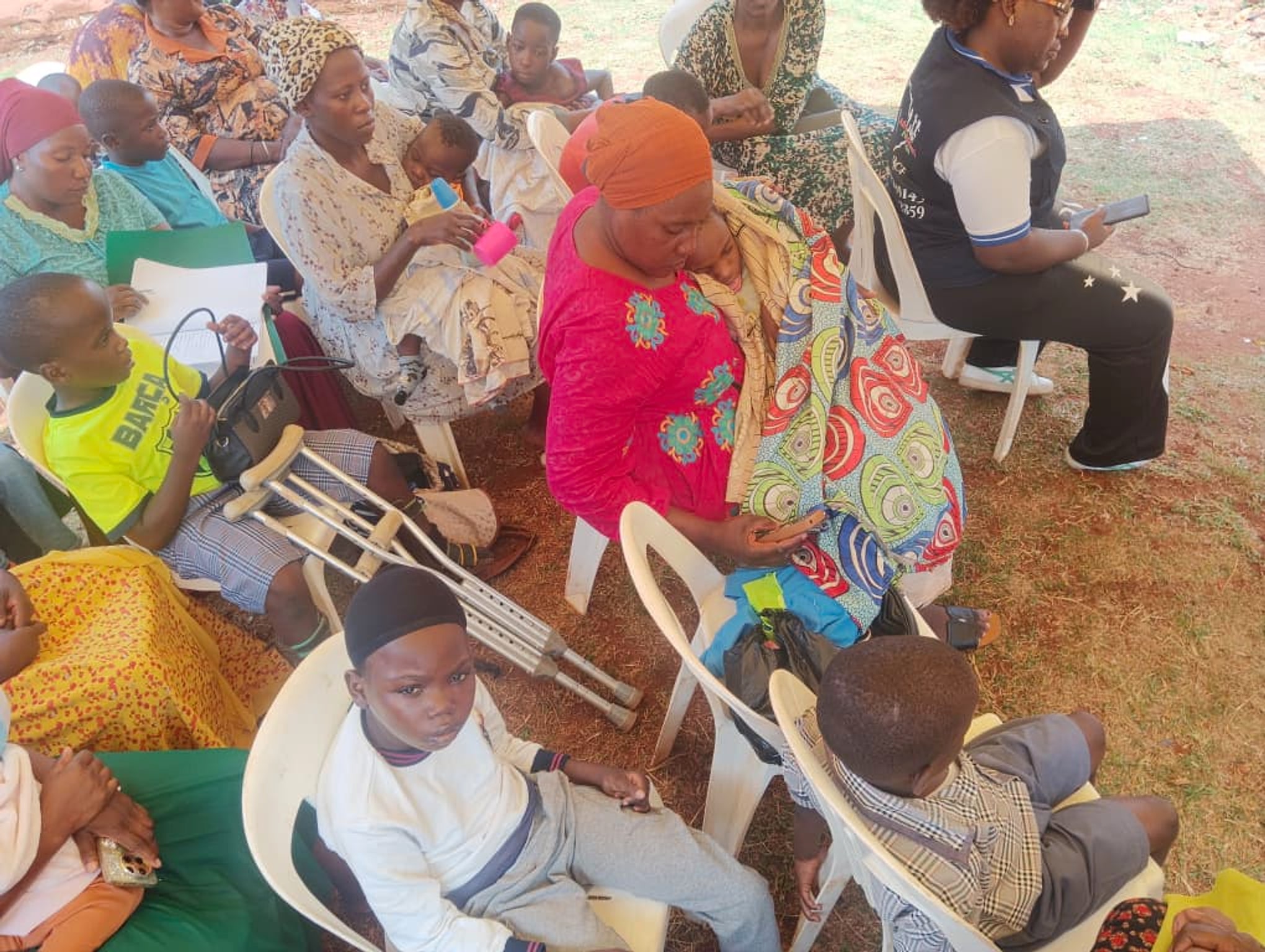 Caregivers and children seated under the tent at the St. Jude Africa office