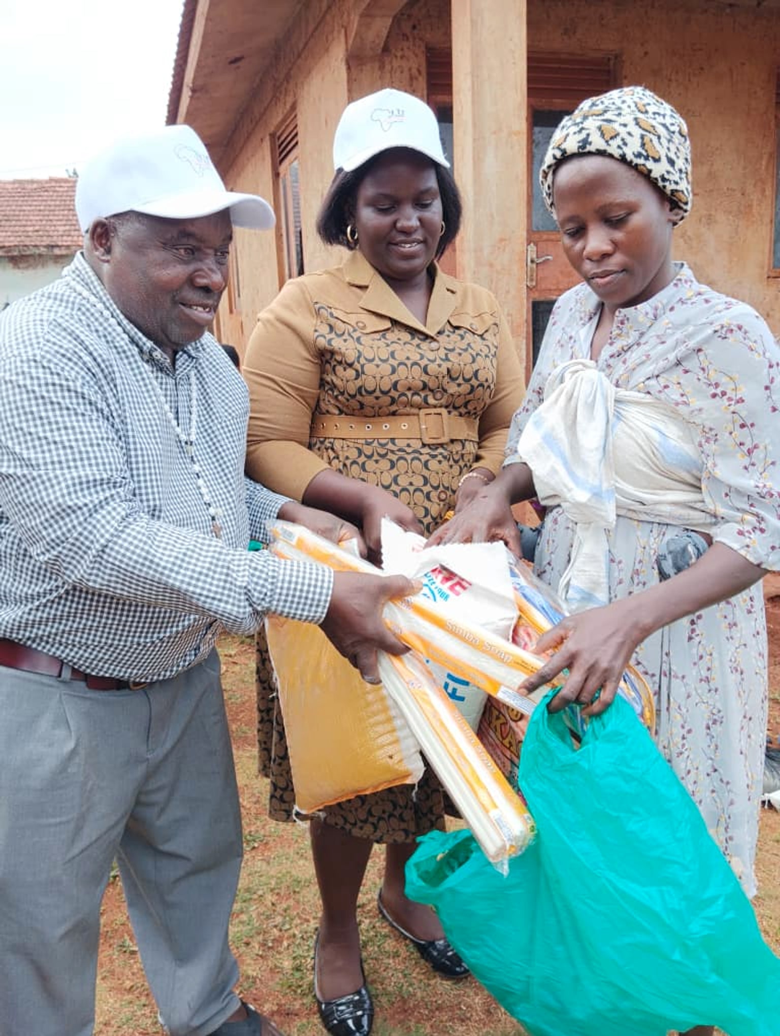 St. Jude Africa team handing food and household supplies to a caregiver